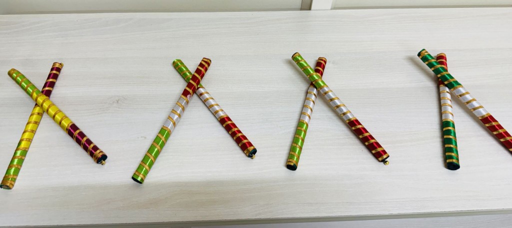 Decorated dandiya sticks laid out for a cultural celebration at the office